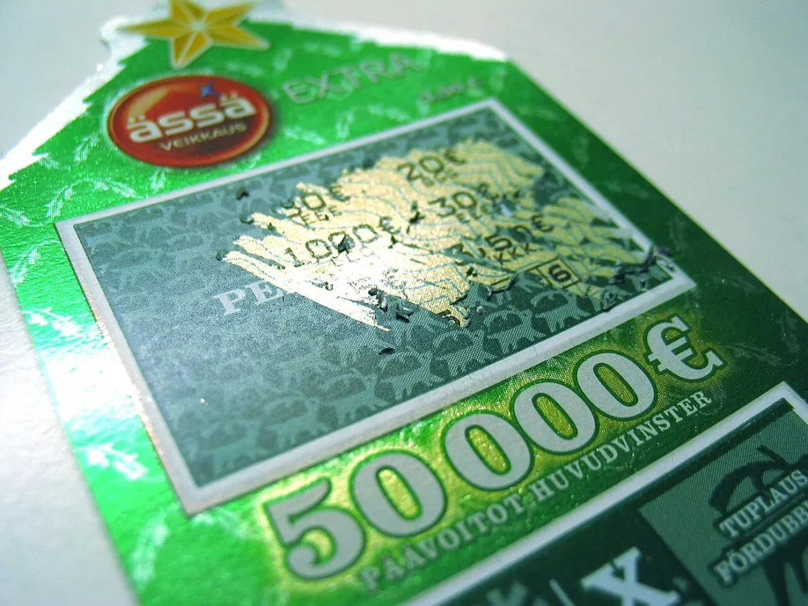 A person scratching a lottery scratch card game ticket