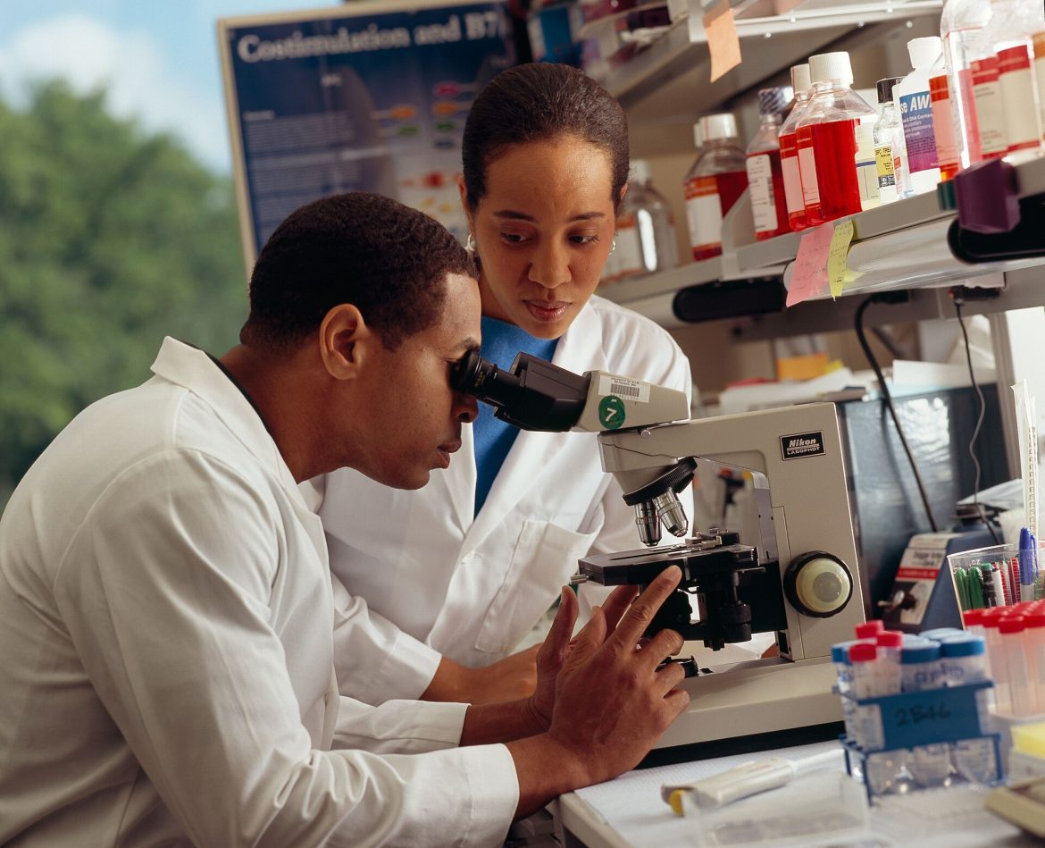 Immunotherapy research: a scientist studying cancer samples under a microscope